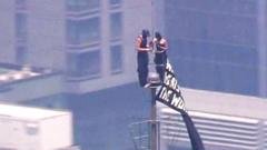 Du žmonės užlipo į Empire State Building viršūnę ir išskleidė plakatą